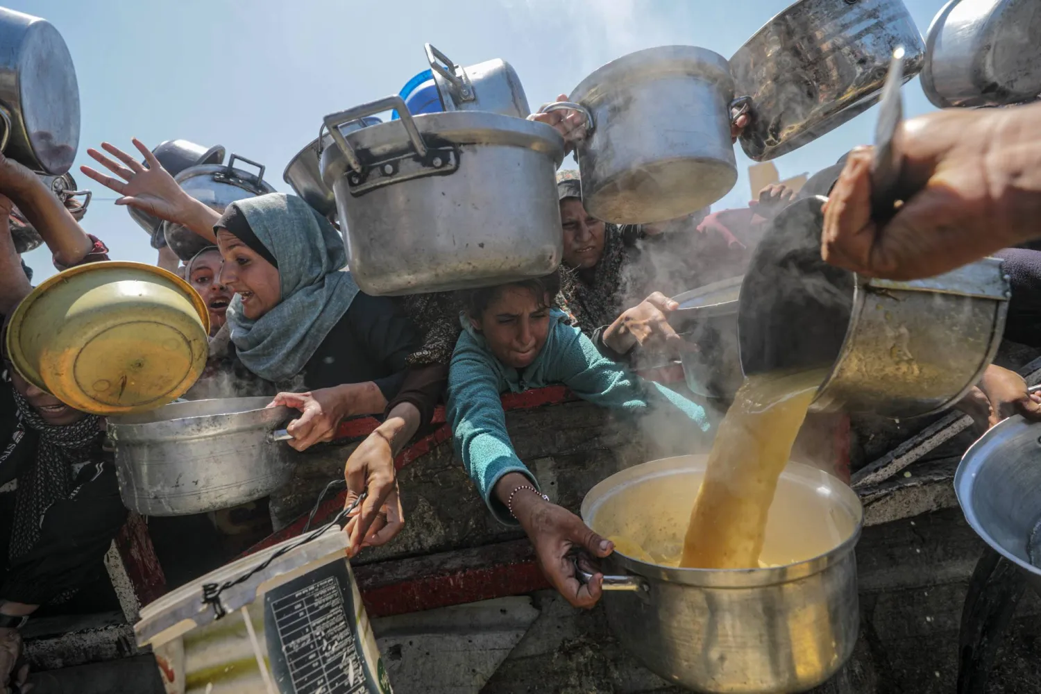 تهافت النازحين على الحصول على طعام من تكية خيرية بمدينة غزة يوم الاثنين (إ.ب.أ)
