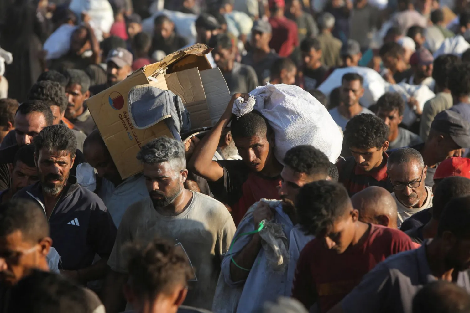 فلسطينيون يحملون أكياس الطحين  في خان يونس بجنوب قطاع غزة 4 أغسطس 2025 (رويترز)