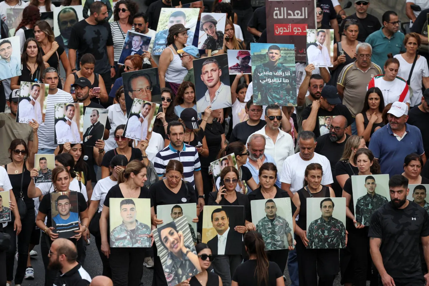 ذوو ضحايا يحملون صورهم في الذكرى الخامسة لانفجار مرفأ بيروت التي صادفت أمس (رويترز)