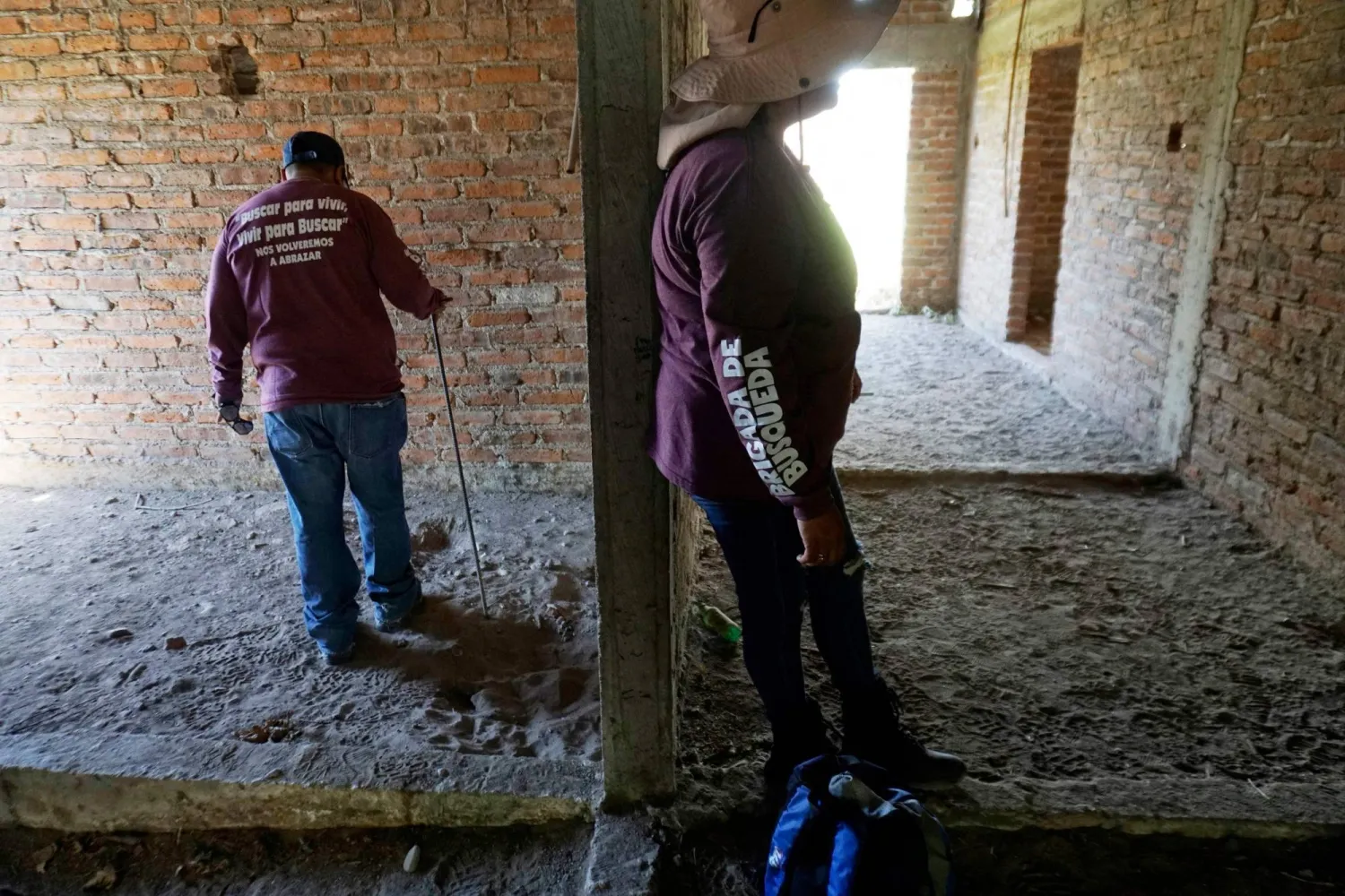 أعضاء من فريق البحث خلال تفتيش المنزل المهجور في غواناخواتو (أ.ف.ب)