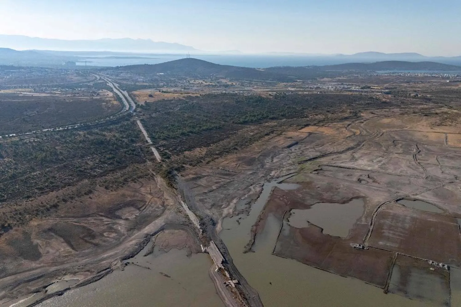 This aerial photograph shows a section of the old Izmir-Cesme highway emerging after the water level dropped at the Alacati Kutlu Aktas Dam in Izmir, on July 30, 2025. (AFP) 
