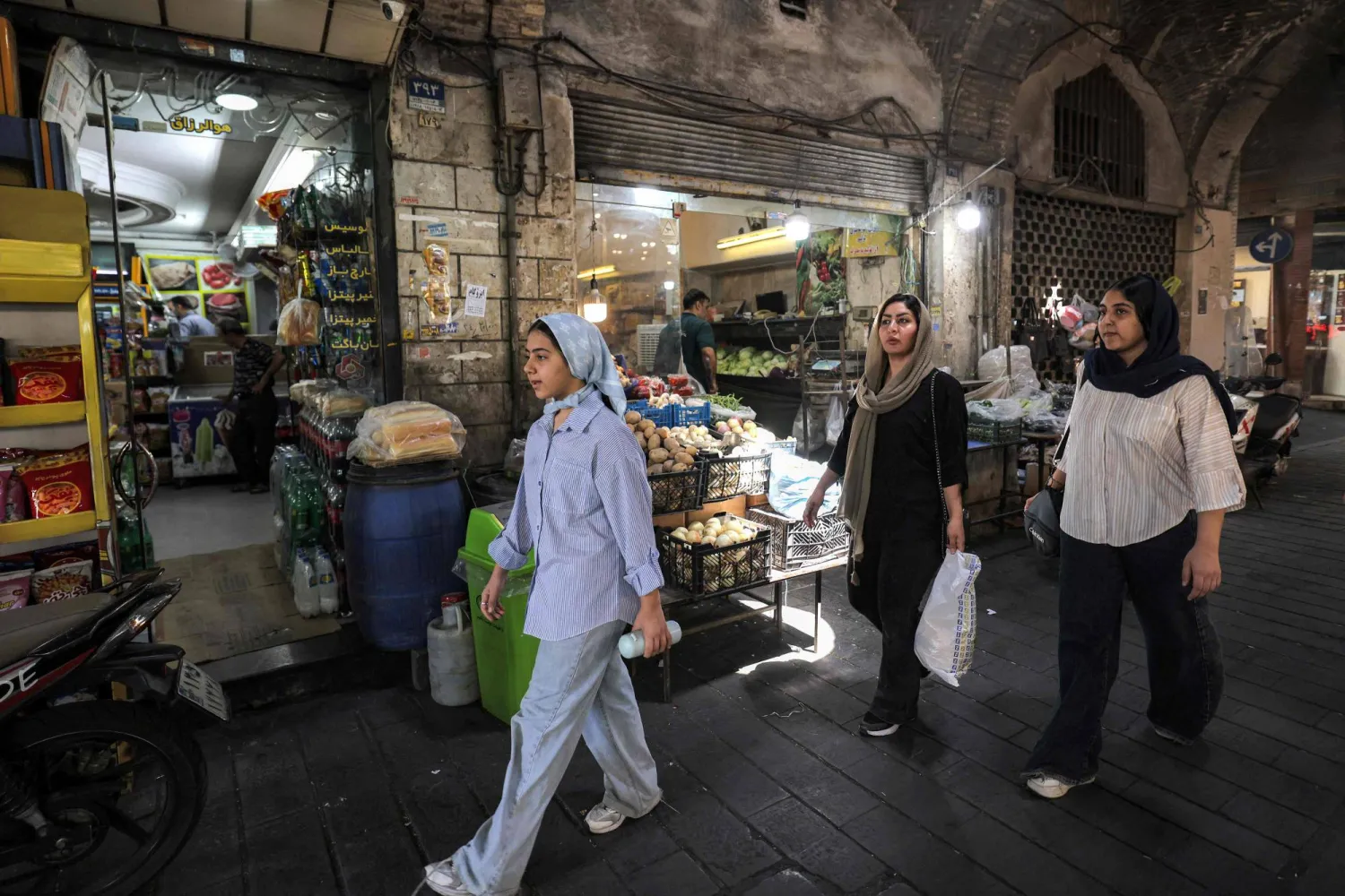 نساء يمشين في أحد أزقة بازار طهران القديم الثلاثاء (أ.ف.ب)