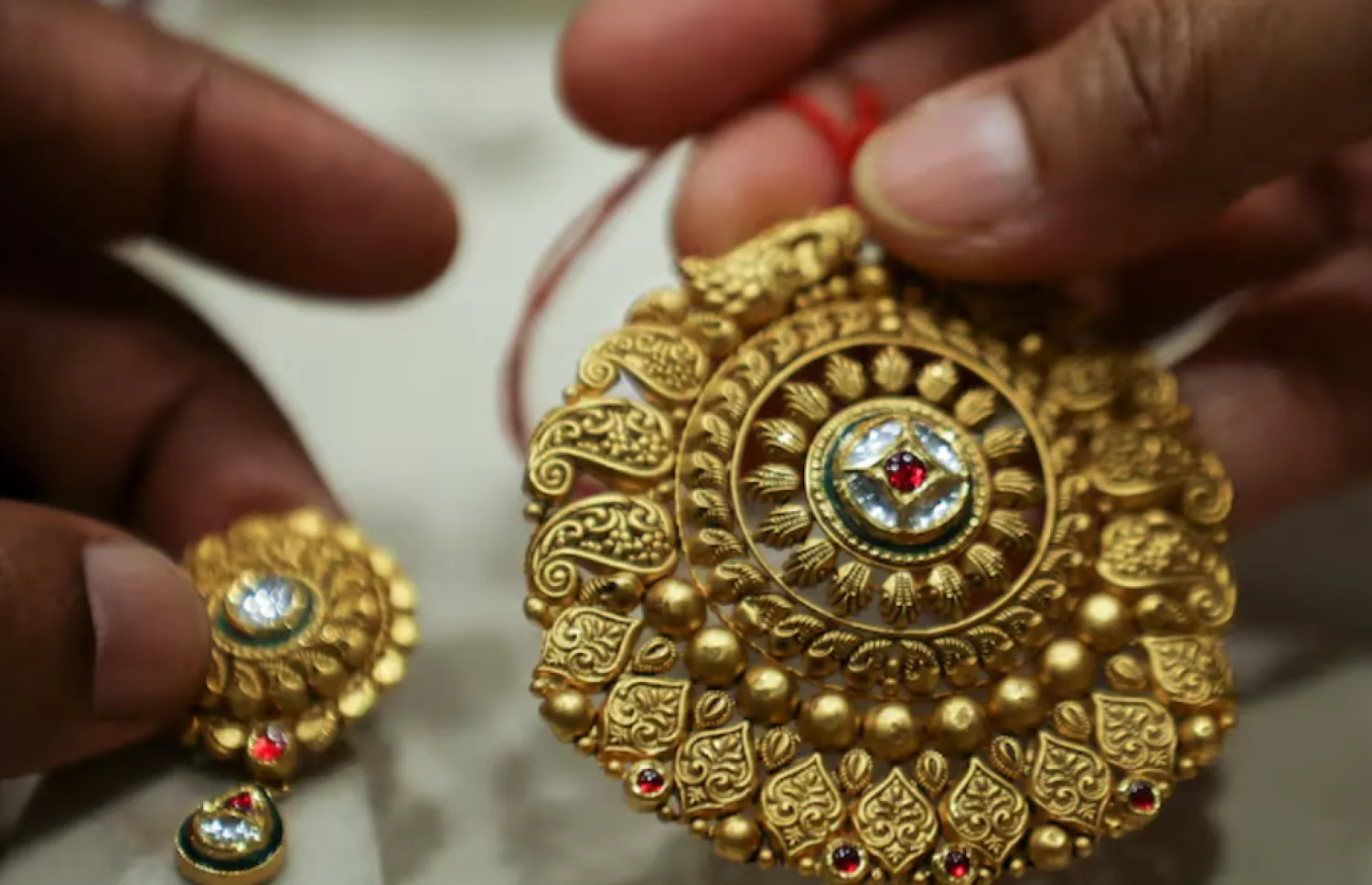 A woman holds a gold ornament at a jewellery shop in the old quarters of Delhi, India, May 24, 2023. REUTERS/Anushree Fadnavis/ File Photo