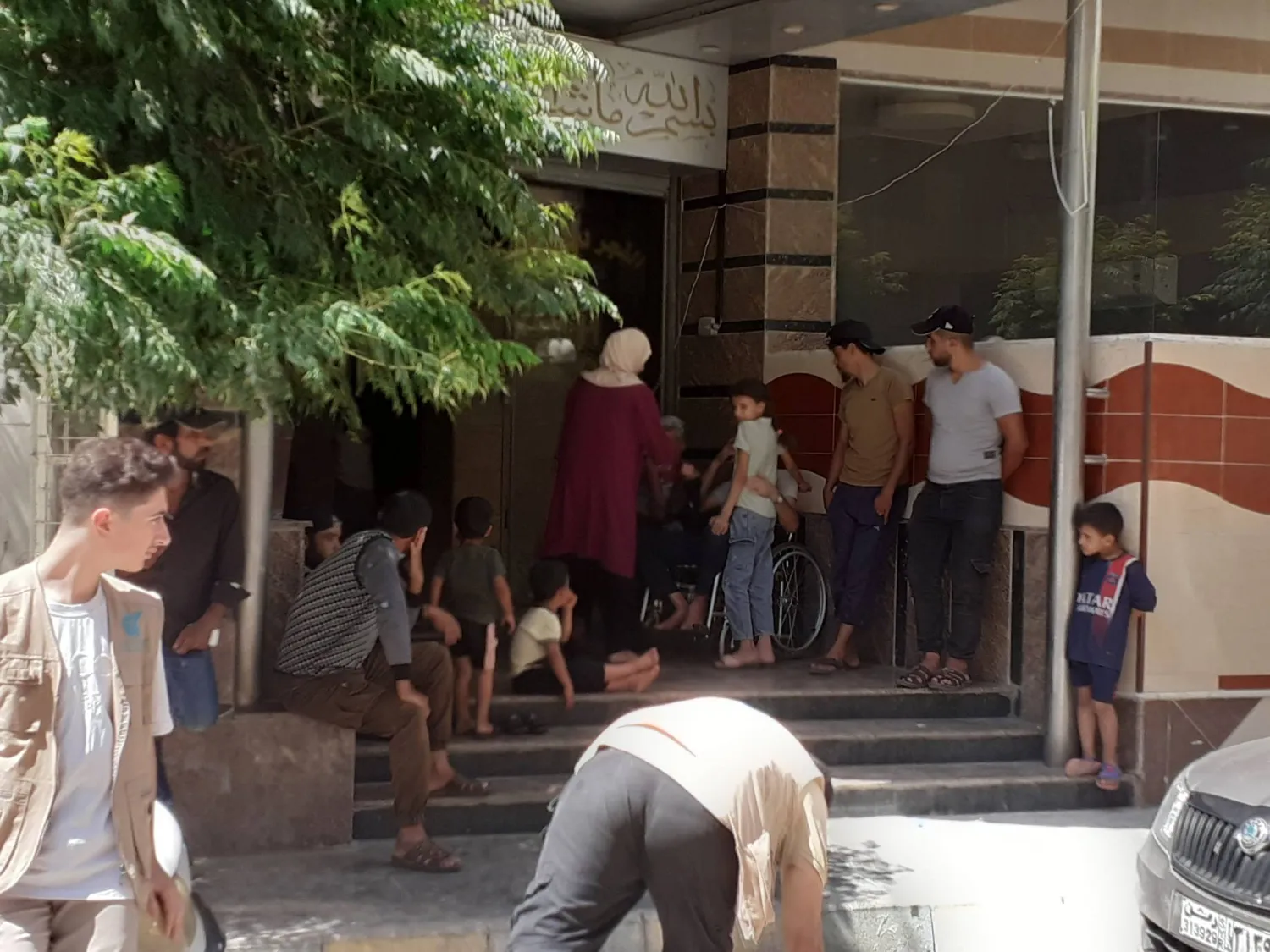 عوائل مهجرة من السويداء أمام أحد فنادق منطقة السيدة زينب (الشرق الأوسط)
