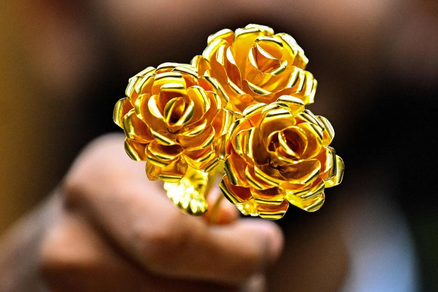 قطعة ذهبية على شكل وردة عيار 24 قيراطاً تزن أونصة واحدة معروضة للبيع في سوق الذهب المركزية في الكويت (أ.ف.ب)