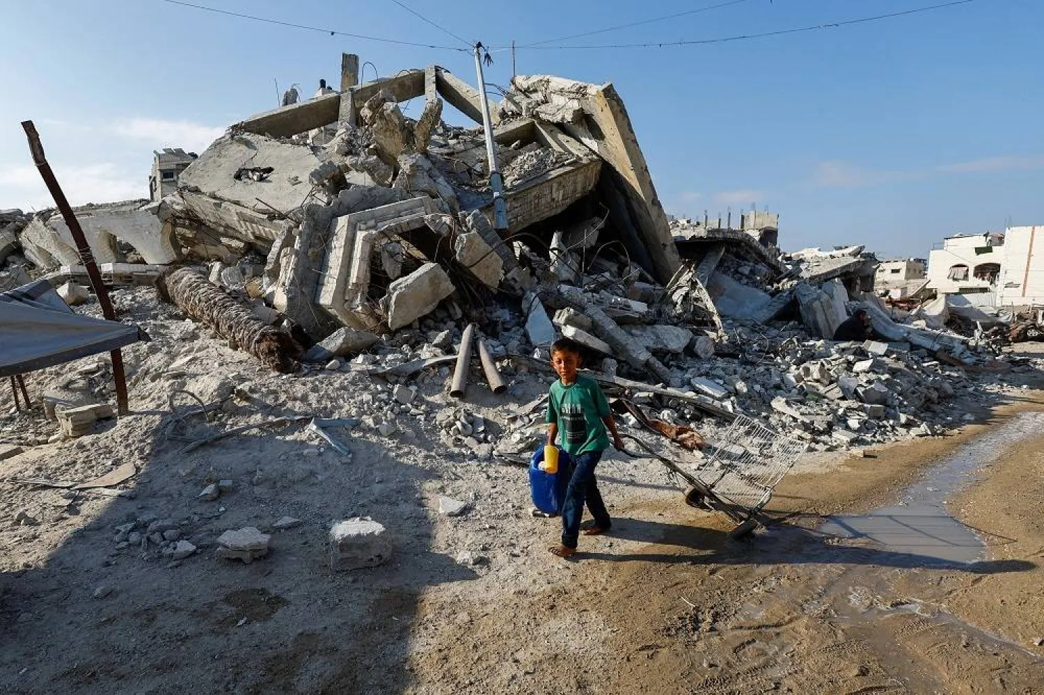 A Palestinian boy walks with a container of water amid shortages, in Gaza City August 6, 2025. (Reuters)