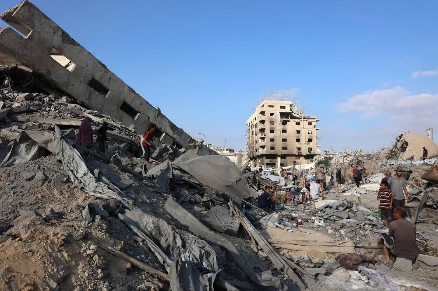 Palestinians inspect the damage after an overnight strike on the Sheikh Radwan Health Center in the north of Gaza City on August 6, 2025. (AFP)