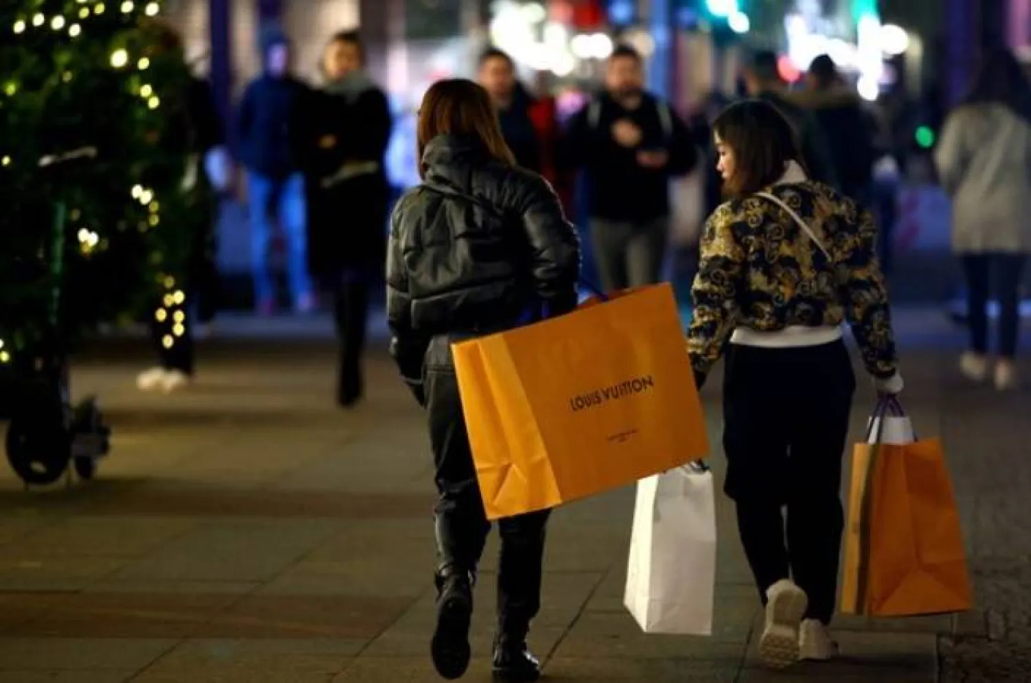 نساء يحملن حقائب تسوُّق أمام متجر «كاديفيه» ببرلين (رويترز)