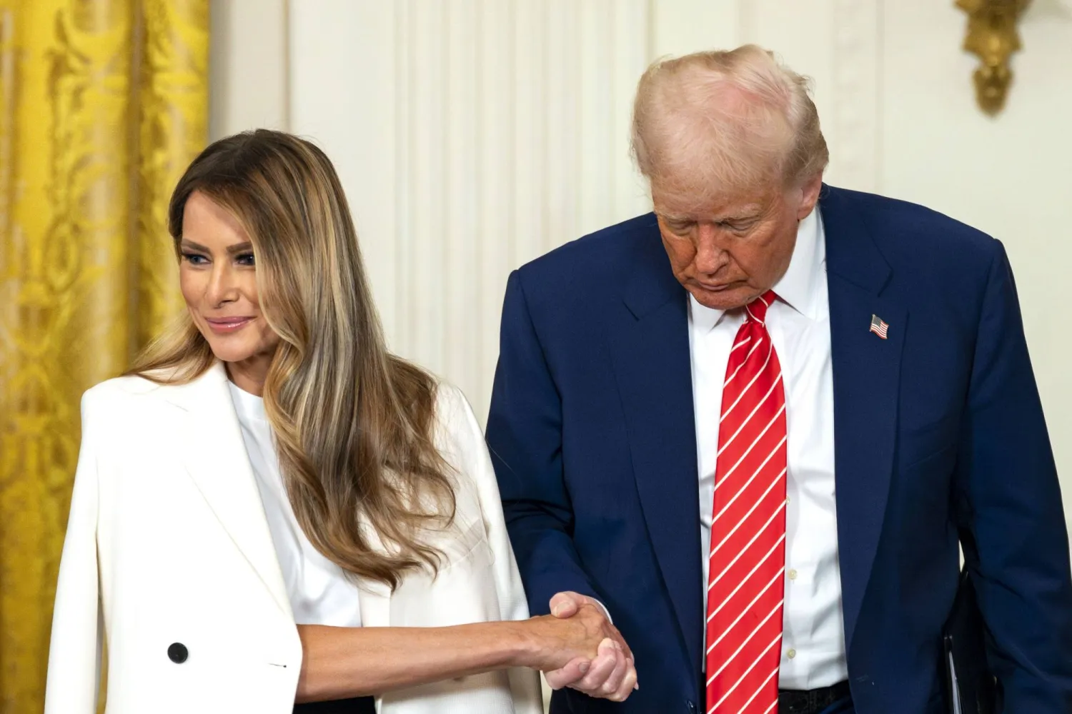 الرئيس الأميركي دونالد ترمب يمسك بيد السيدة الأولى ميلانيا (د.ب.أ)