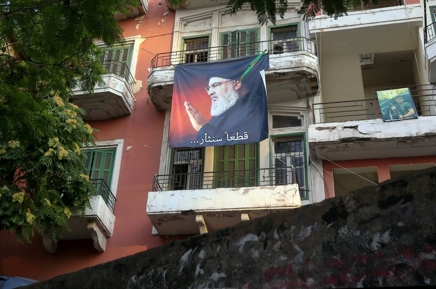 لافتة عليها صورة الأمين العام الأسبق لـ«حزب الله» حسن نصر الله (إ.ب.أ)