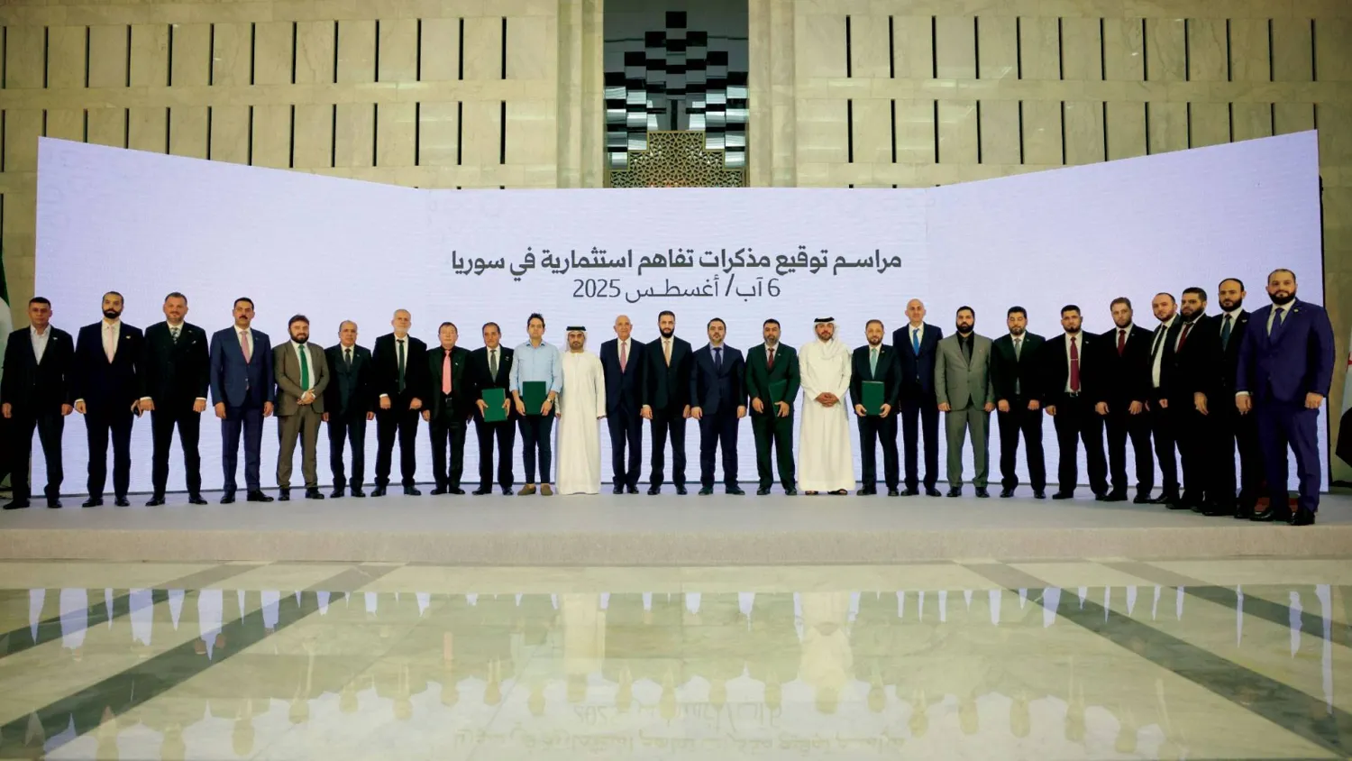  صورة تذكارية يتوسطها الرئيس الشرع والسفير براك بمناسبة مراسم توقيع اتفاقيات لتنفيذ مشاريع استثمارية استراتيجية في سوريا (الرئاسة السورية)