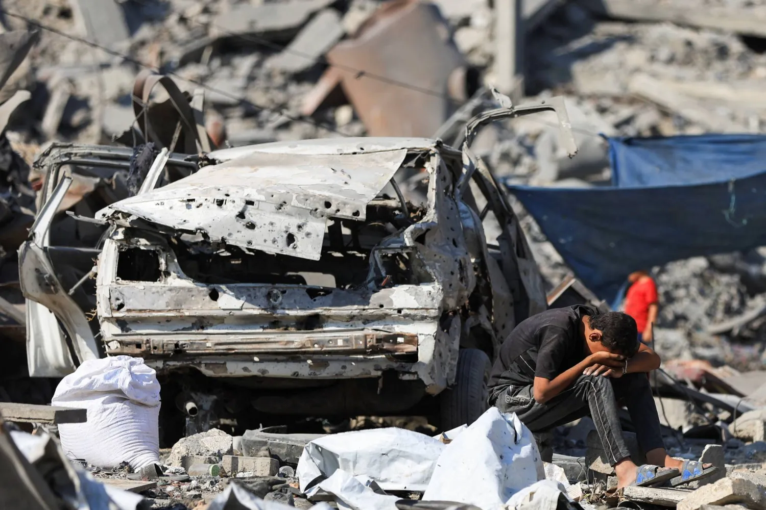A Palestinian boy reacts at the site surrounding an evacuated UNRWA clinic where displaced people were taking shelter, following an overnight Israeli strike, in Gaza City August 6, 2025. REUTERS/Dawoud Abu Alkas
