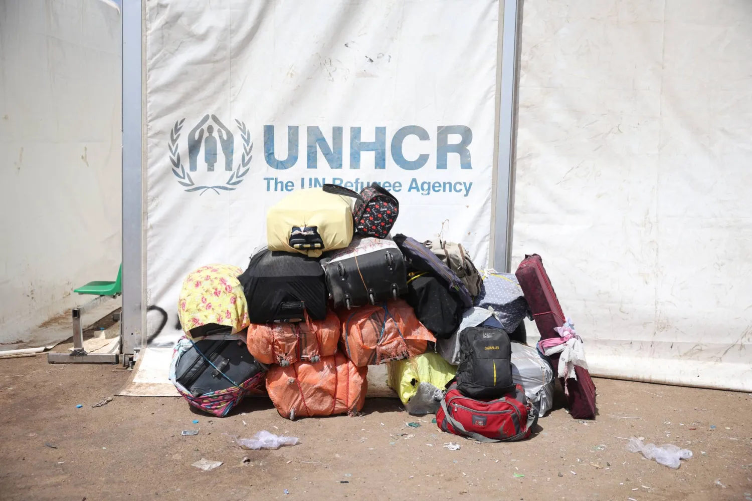 حقائب تخص أفغاناً مرحَّلين من إيران ملقاة بجوار خيمة تابعة للمفوضية السامية للأمم المتحدة لشؤون اللاجئين في مخيم للمهاجرين العائدين بالقرب من معبر إسلام قلعة الحدودي في ولاية هرات بأفغانستان.. 22 يوليو 2025 (رويترز)