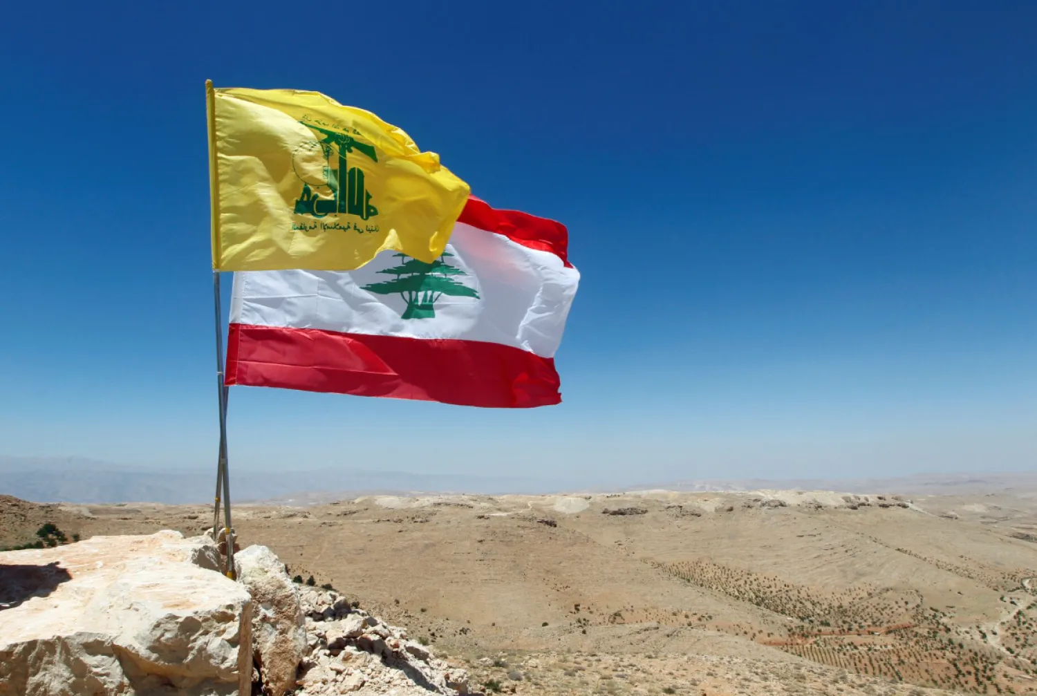 Lebanese and Hezbollag flags are seen in Juroud Arsal, Syria-Lebanon border, July 25, 2017. REUTERS/Mohamed Azakir 