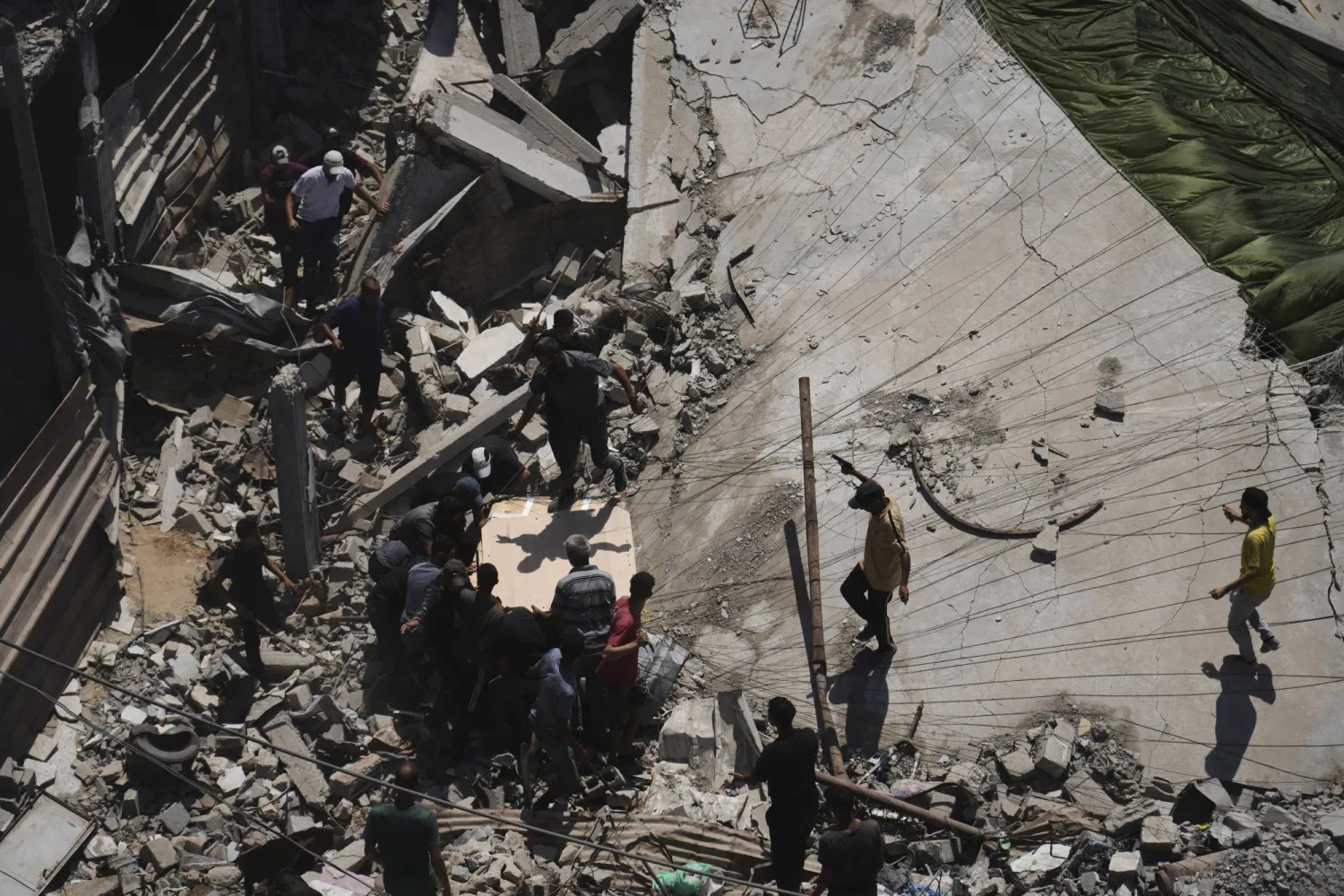 فلسطينيون يسارعون لجمع المساعدات الإنسانية التي أُسقطت جواً على مدينة غزة (أ.ب)