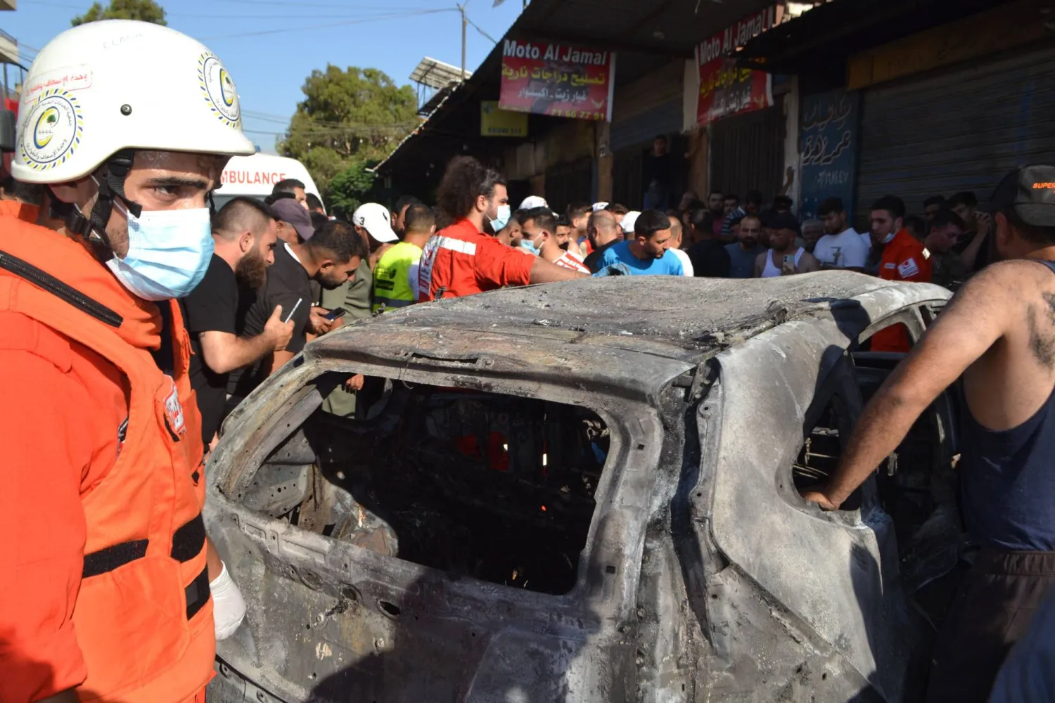 مُسعفون لبنانيون يتفقدون سيارة محترقة استُهدفت في غارة جوية إسرائيلية بشمال البلاد (أ.ف.ب)