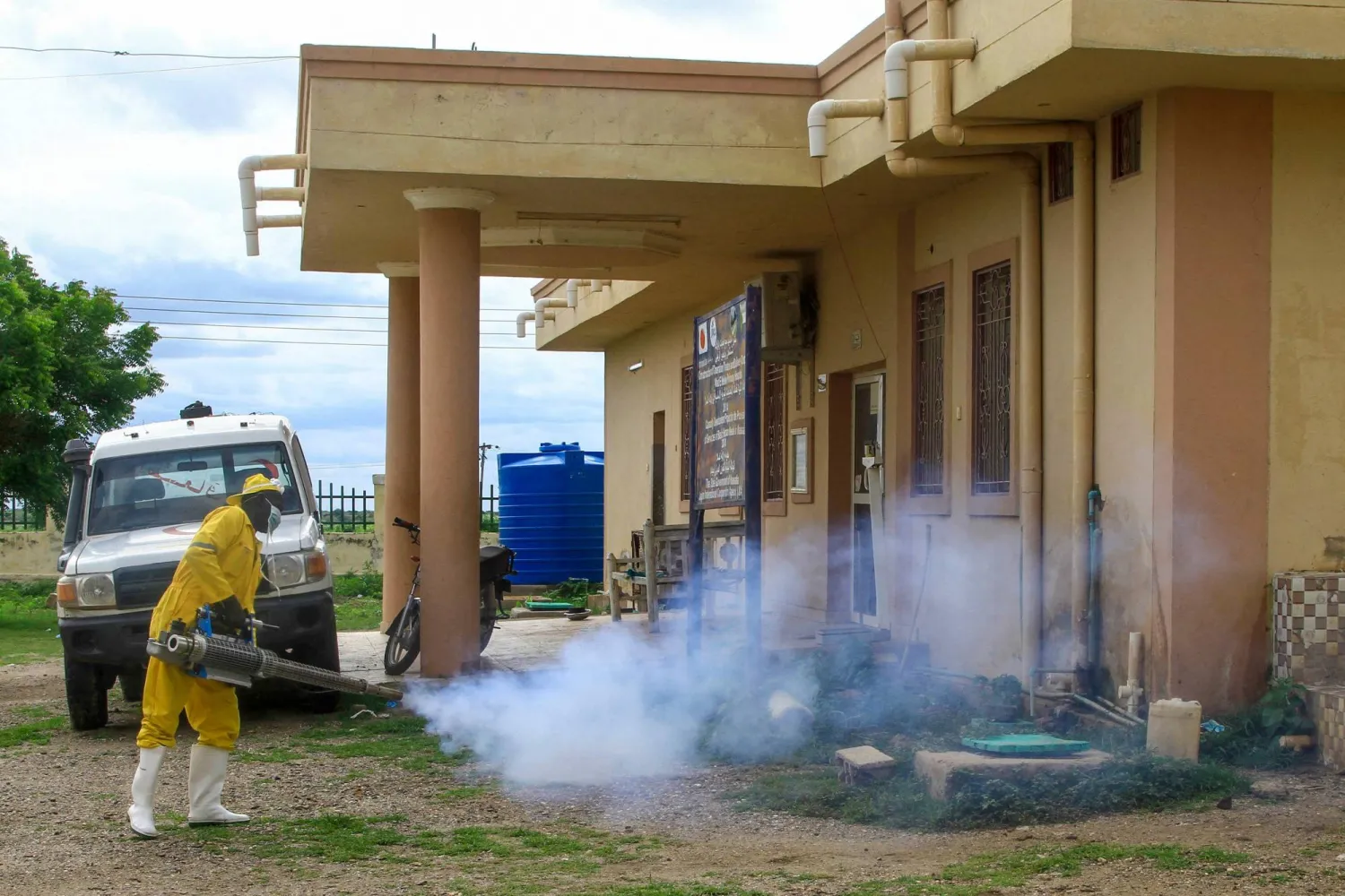 A man disinfects a rural isolation center where patients are being treated for cholera in Wad Al-Hilu in Kassala state in eastern Sudan, on August 17, 2024. (Photo by Ebrahim Hamid / AFP)