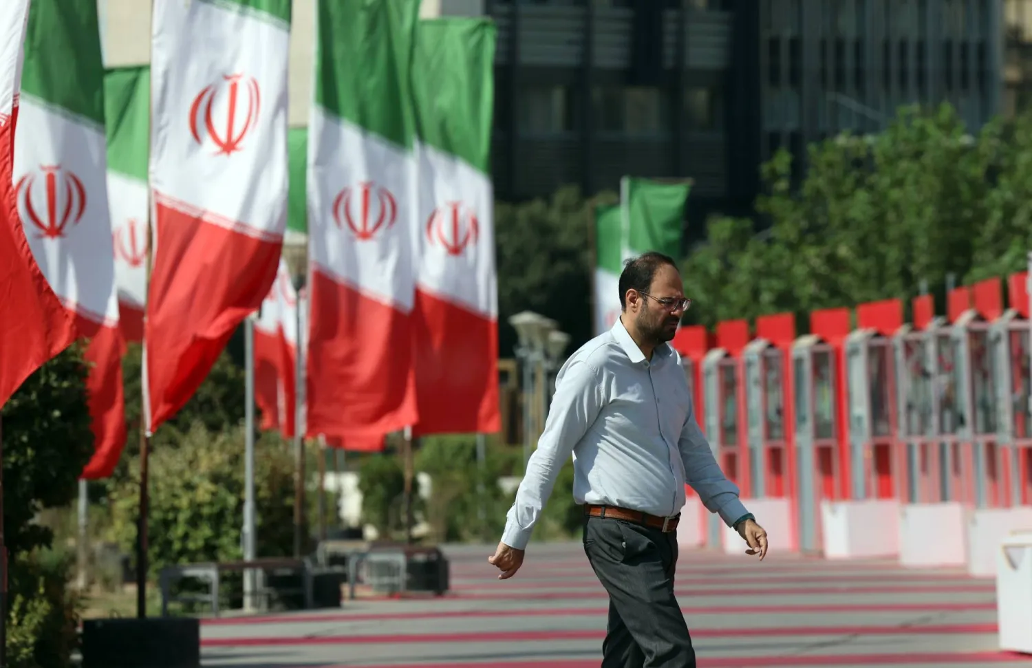 A person walks by a row of Iranian flags on a street in Tehran, Iran, 06 August 2025. EPA/ABEDIN TAHERKENAREH