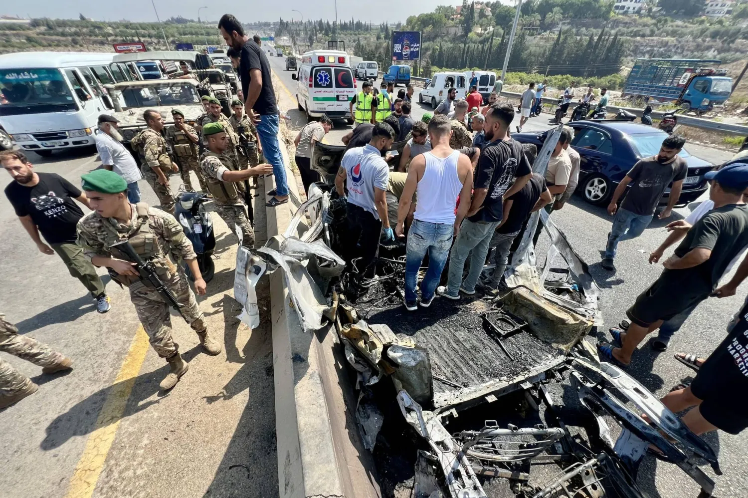 Lebanese soldiers and civilians inspect the wreckage of a car following an Israeli drone strike along the international highway between Sidon and Tyre, in the town of Ansariyeh, southern Lebanon, 08 August 2025. EPA/STRINGER