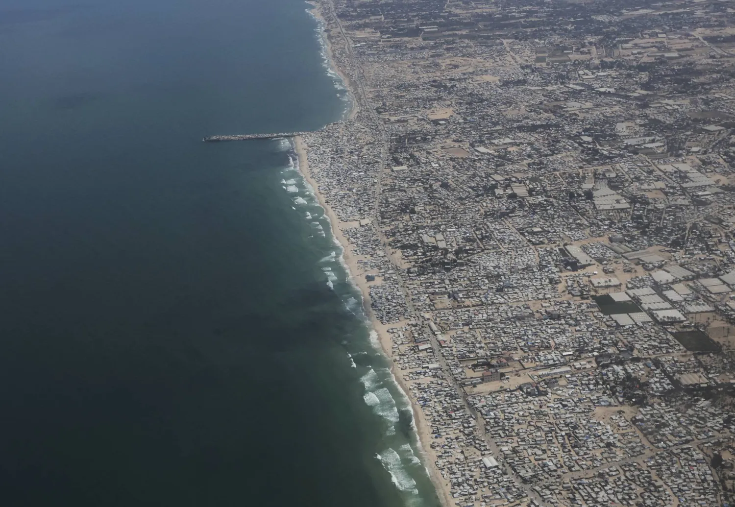 صورة تظهر خياماً على شاطئ البحر والمناطق المحيطة بقطاع غزة من طائرة تابعة لسلاح الجو الأردني أثناء إسقاط مساعدات إنسانية للفلسطينيين... 7 أغسطس 2025 (أ.ب)