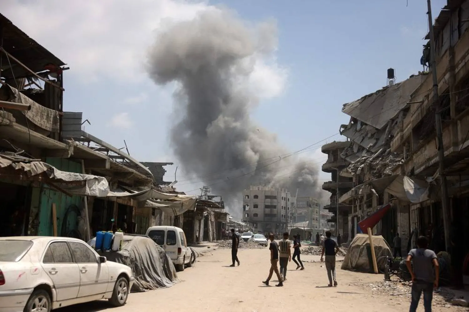 Palestinian watch as a plume of smoke rises during an Israeli strike on Gaza City's southern al-Zeitoun neighborhood on August 8, 2025. (AFP)