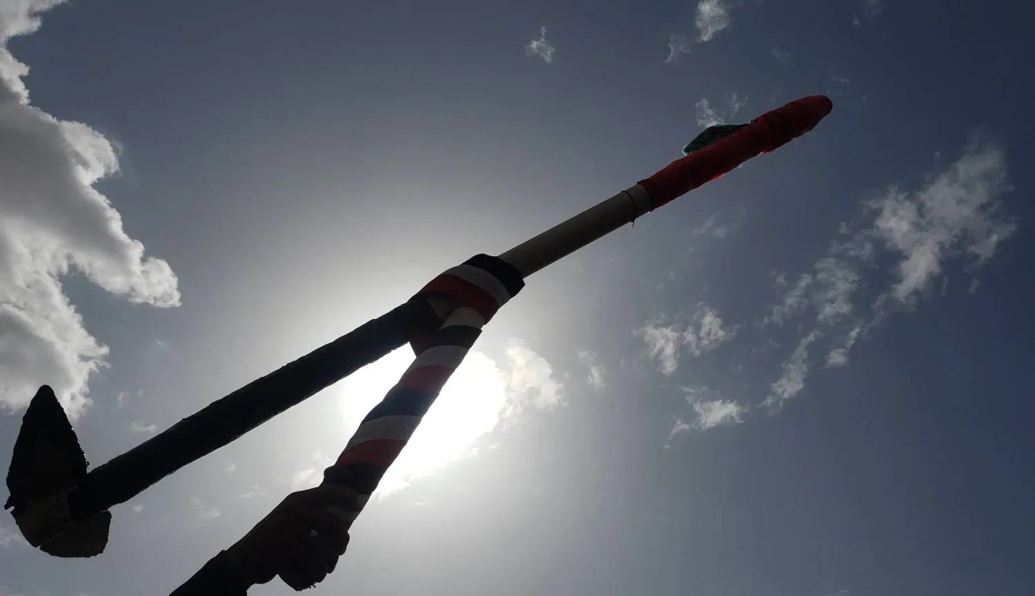 أحد أنصار الحوثيين يحمل مجسماً لطائرة مسيرة خلال احتجاج في صنعاء (إ.ب.أ)