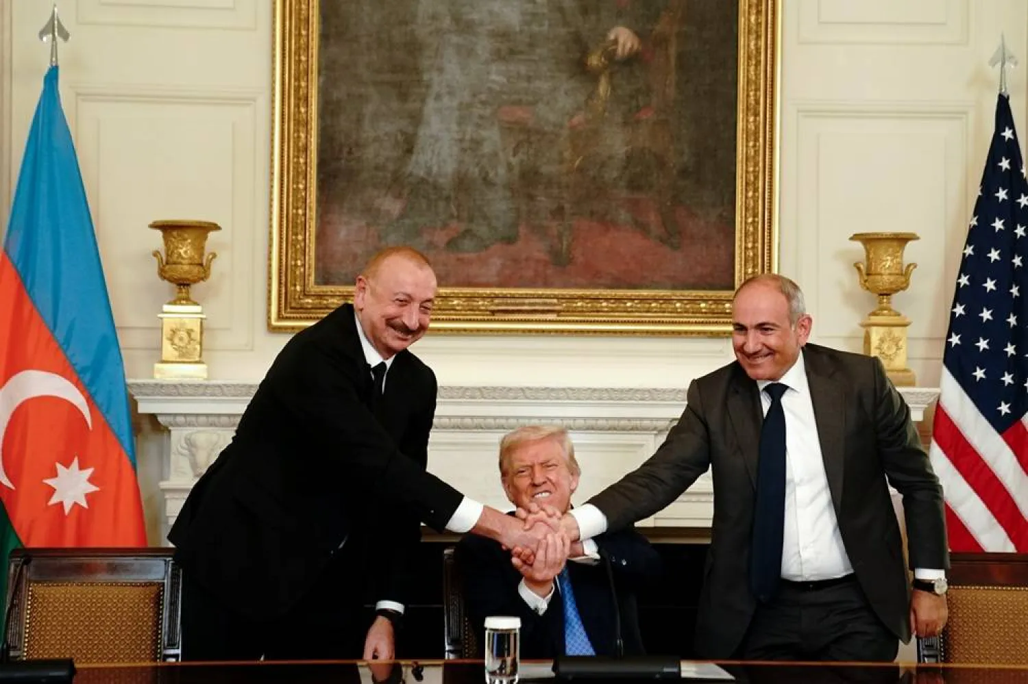 (L-R) Azerbaijan's President Ilham Aliyev, US President Donald Trump, and Armenia's Prime Minister Nikol Pashinyan join hands during a signing ceremony in the State Dining Room of the White House in Washington, DC, USA, 08 August 2025. (EPA)