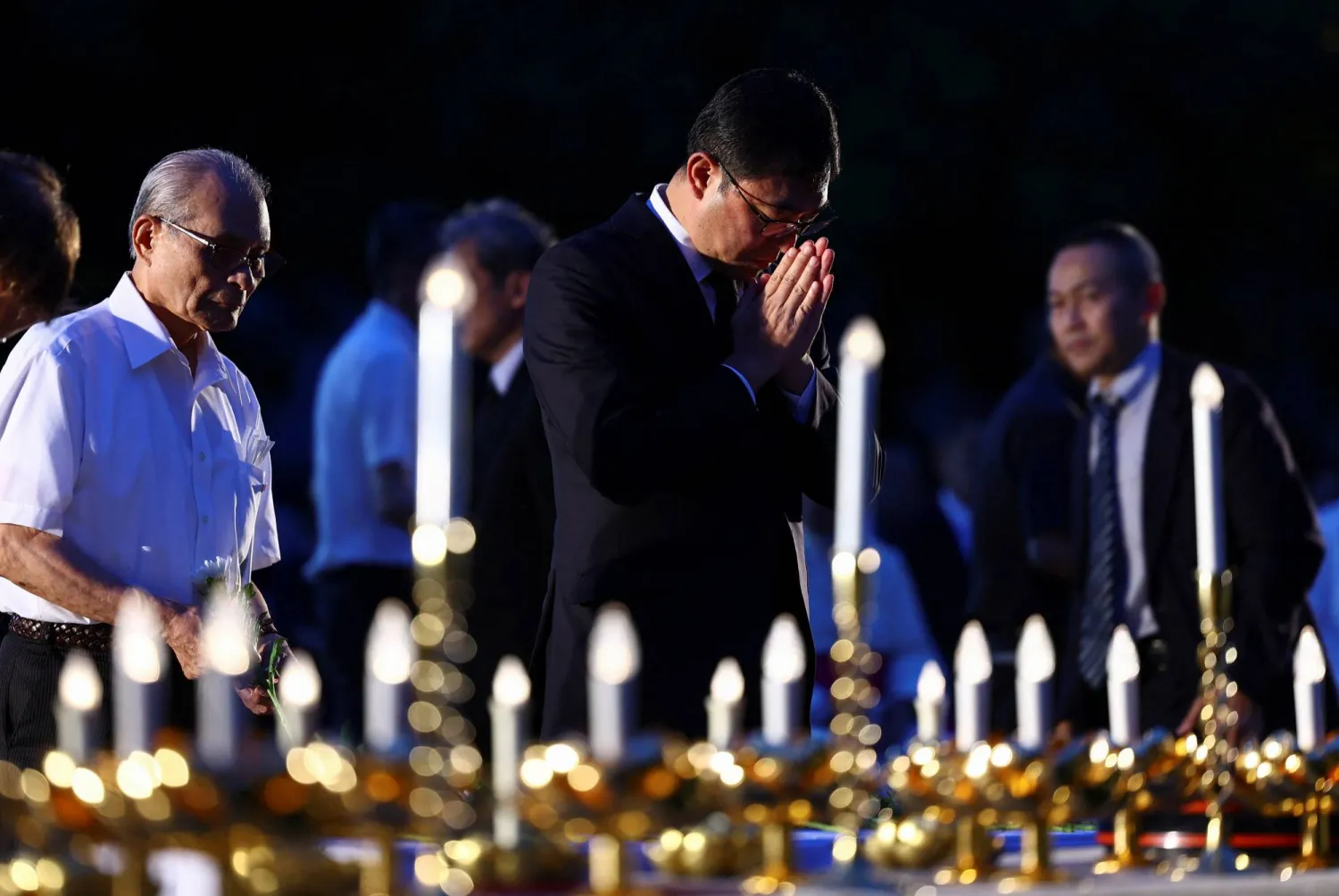 أشخاص يصلّون خلال احتفال لإحياء ذكرى ضحايا القنبلة الذرية بحديقة هيبوسنتر في ناغاساكي (رويترز)