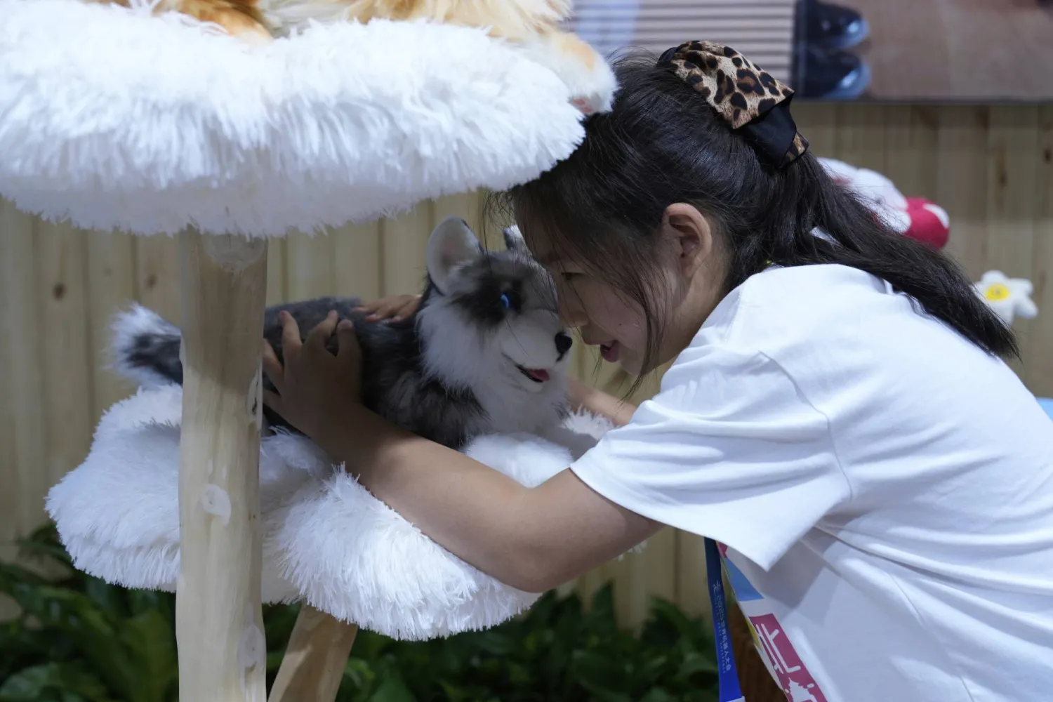 يحمل أحد الزوار حيواناً أليفاً روبوتياً في مؤتمر الروبوتات العالمي لعام 2025 في بكين (أ.ب)