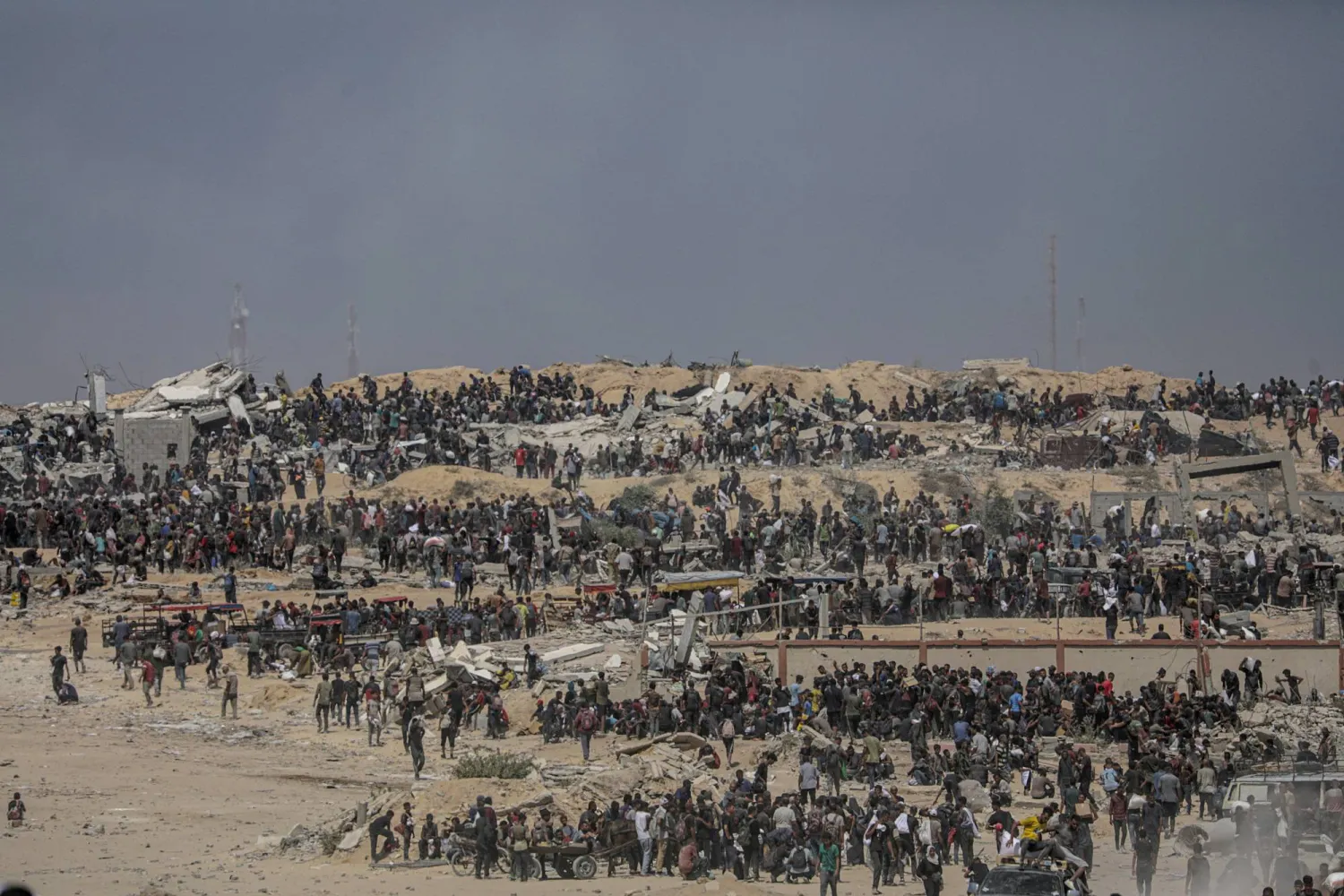 نازحون فلسطينيون ينتظرون شاحنات مساعدات قرب نقطة توزيع أغذية في زيكيم شمال قطاع غزة (إ.ب.أ)