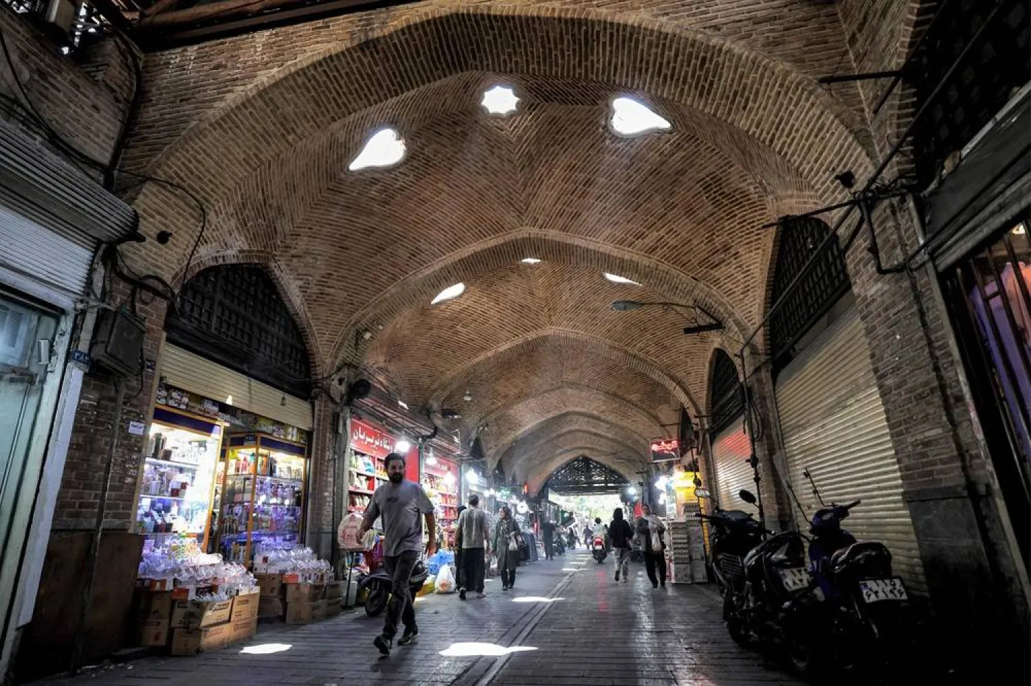  People walk along an alley at the old Shapur Bazaar in southern Tehran on August 5, 2025. (AFP) 