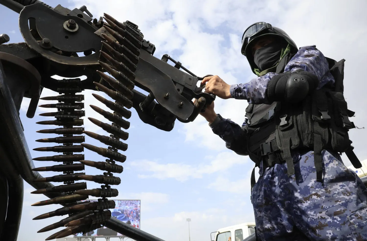 عنصر حوثي يمسك رشاشاً ثقيلاً على متن عربة أمنية (إ.ب.أ)