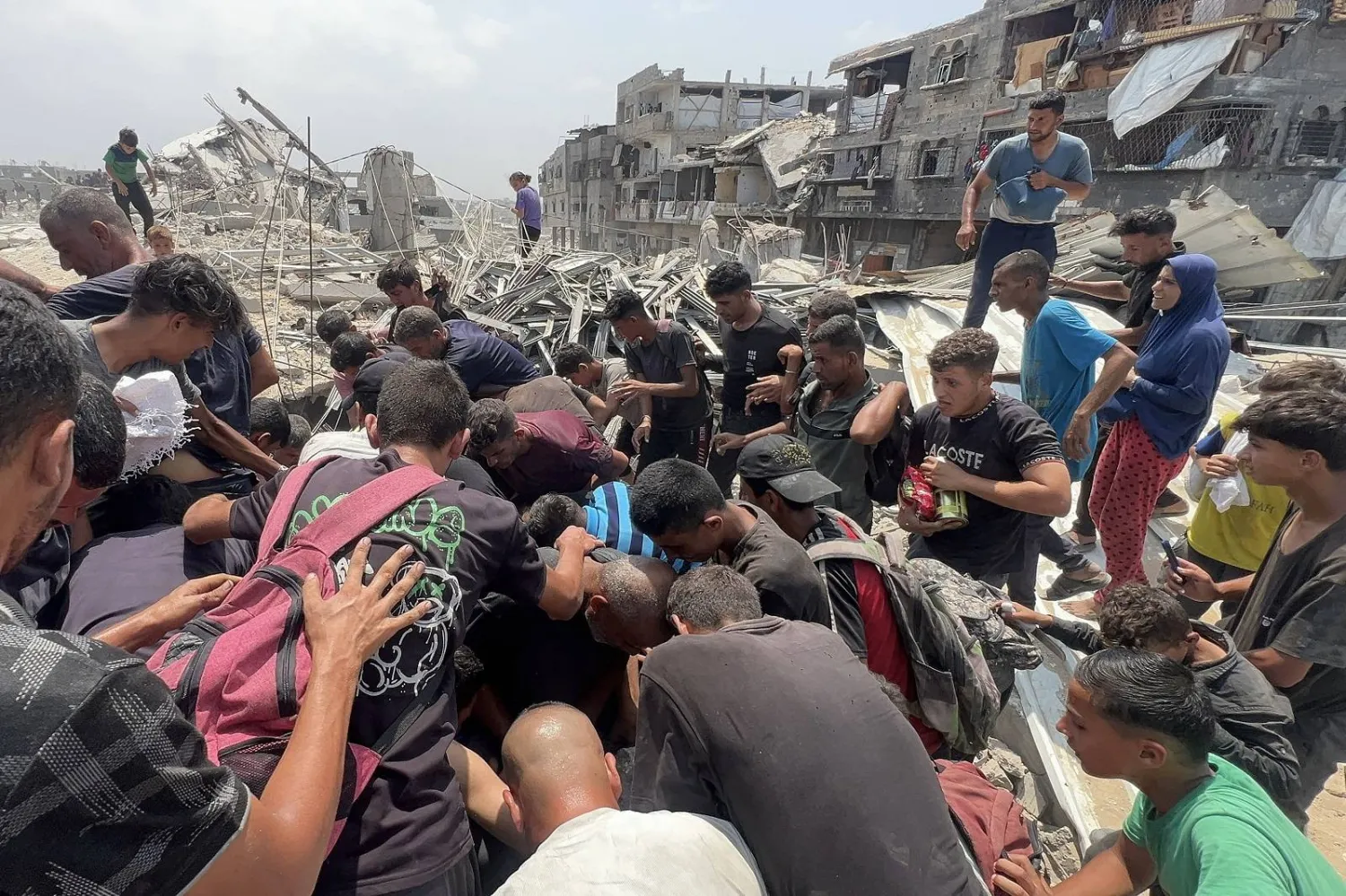 فلسطينيون يتدافعون حول طرد إنساني أسقطته طائرة عسكرية في جباليا (أ.ف.ب)