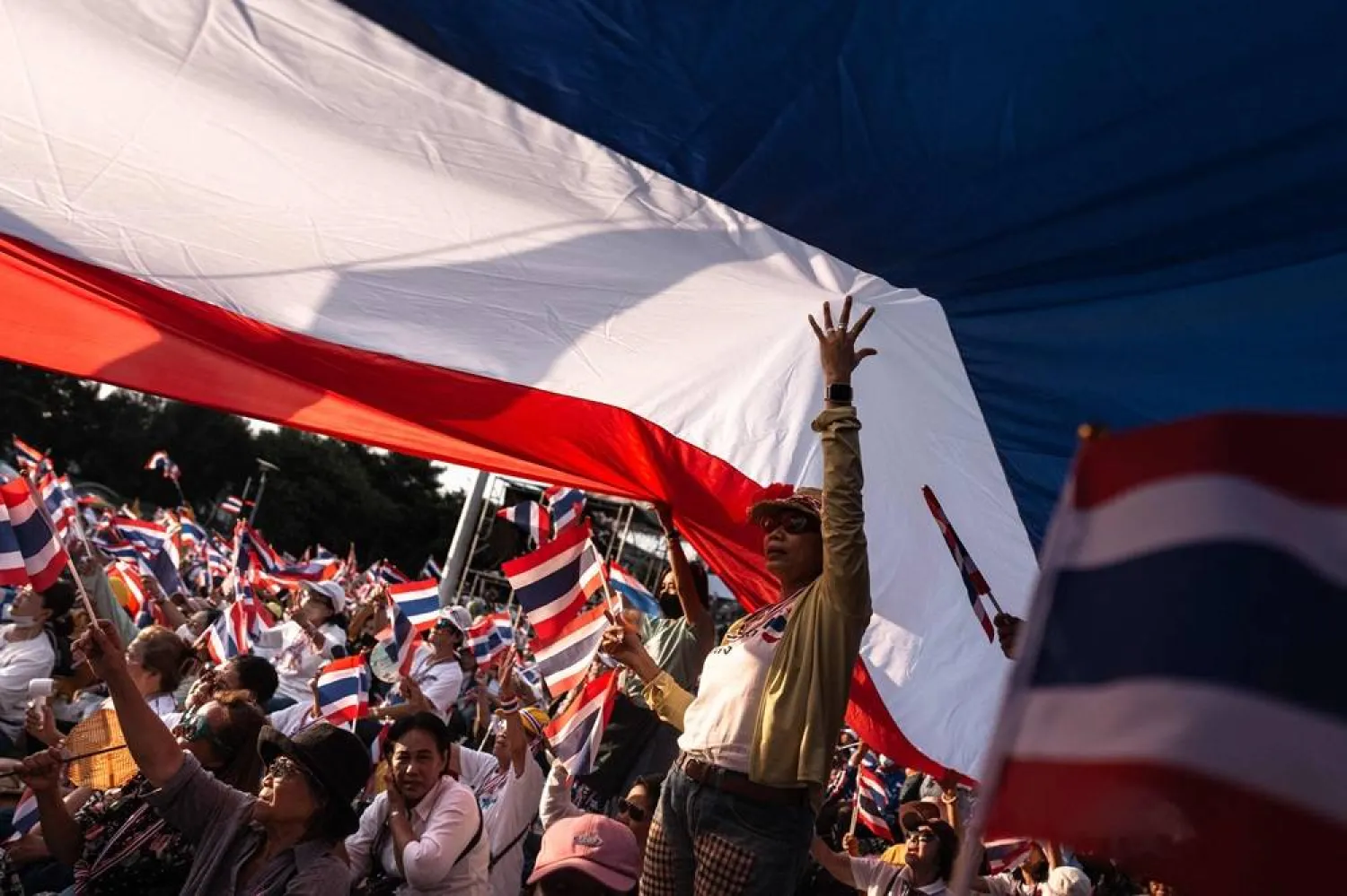 Anti-government protesters hold Thai national flags during a rally to condemn war with Cambodia and demand the resignation of Thailand's suspended prime minister Paetongtarn Shinawatra, at Victory Monument in Bangkok on August 2, 2025. (AFP)