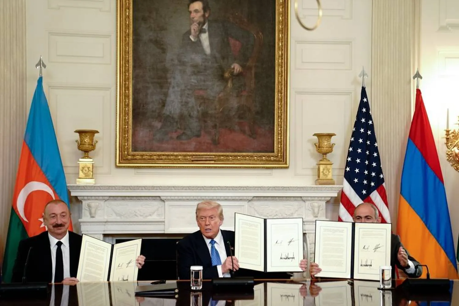 (L-R) Azerbaijan's President Ilham Aliyev, US President Donald Trump, and Armenia's Prime Minister Nikol Pashinyan display the signed agreements during a signing ceremony in the State Dining Room of the White House in Washington, DC, USA, 08 August 2025. (EPA)