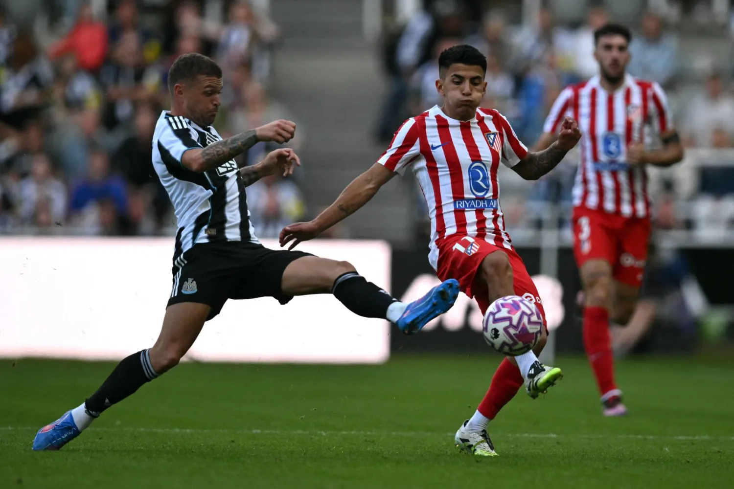 كيران تريبيير مدافع نيوكاسل في صراع على الكرة مع ألمادا لاعب أتلتيكو (أ.ف.ب)
