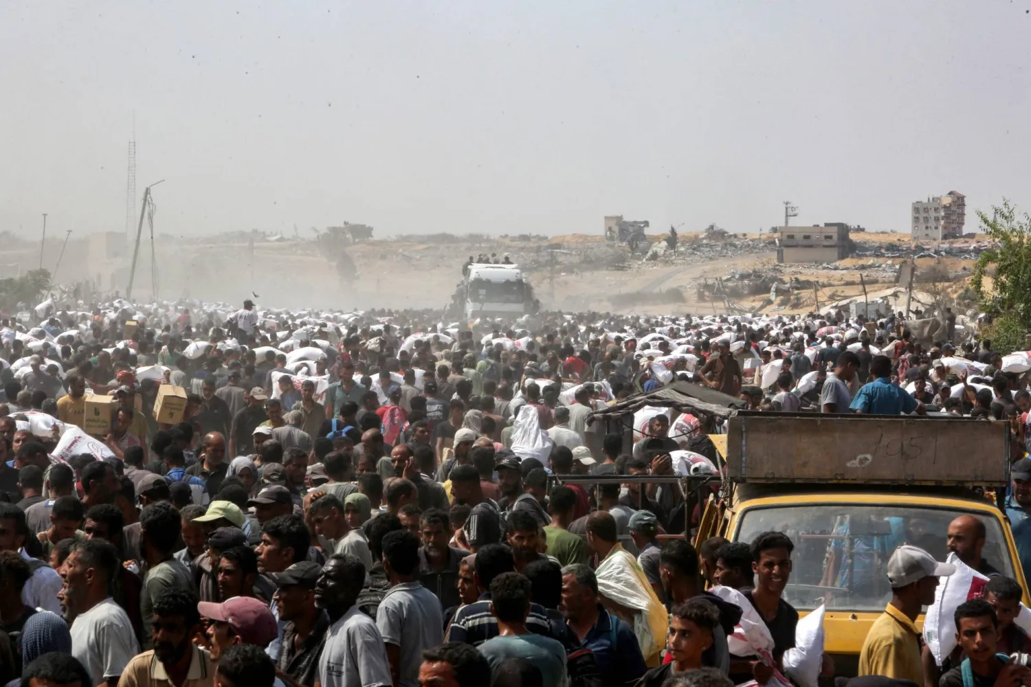 Displaced Palestinians carry food parcels as they raid trucks carrying humanitarian aid in Khan Yunis, in the southern Gaza Strip on August 9, 2025. (Photo by AFP)