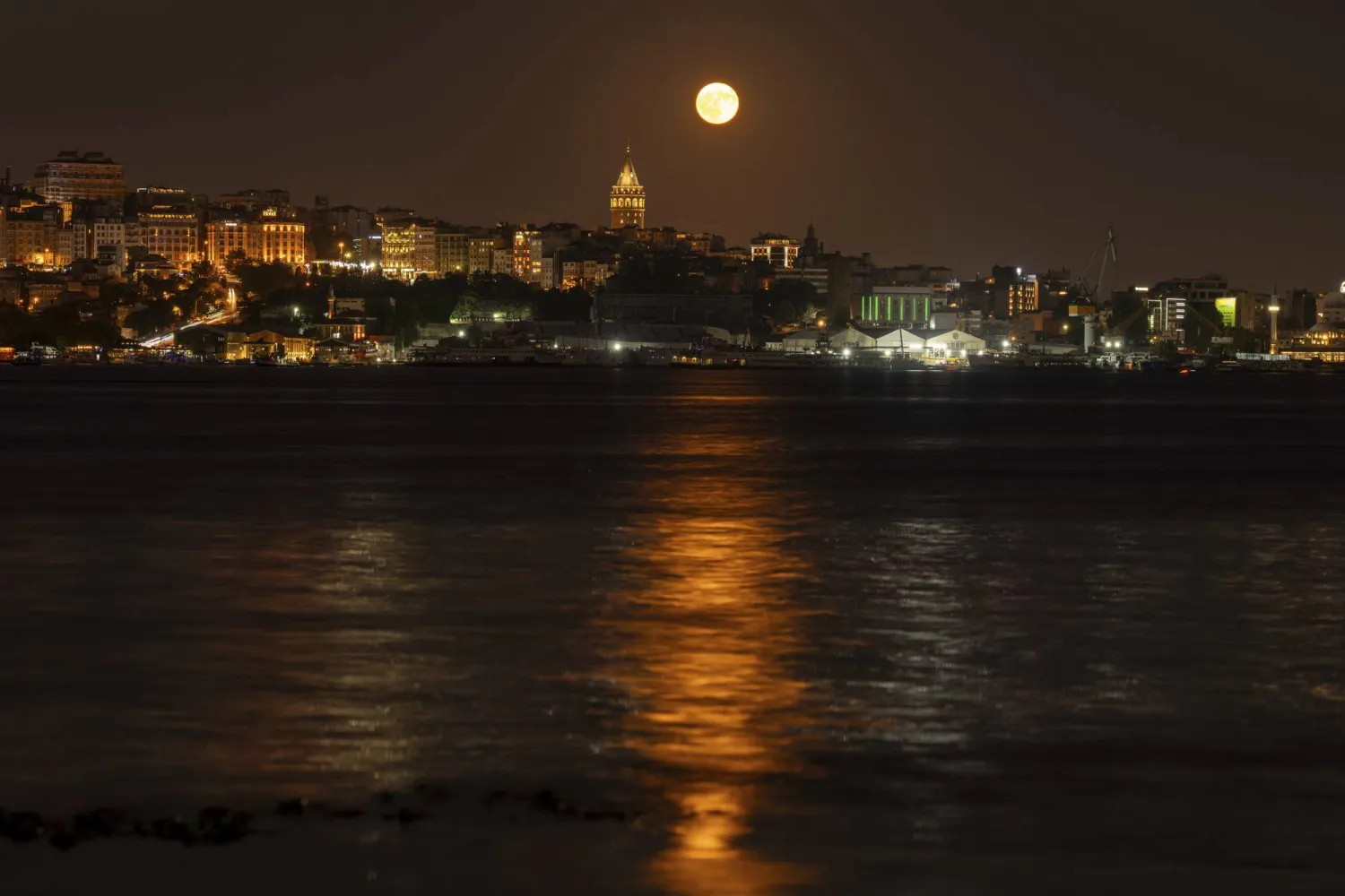 A full Sturgeon moon rises behind Galata tower in Istanbul, Saturday, Aug. 9, 2025. (AP Photo/Emrah Gurel)
