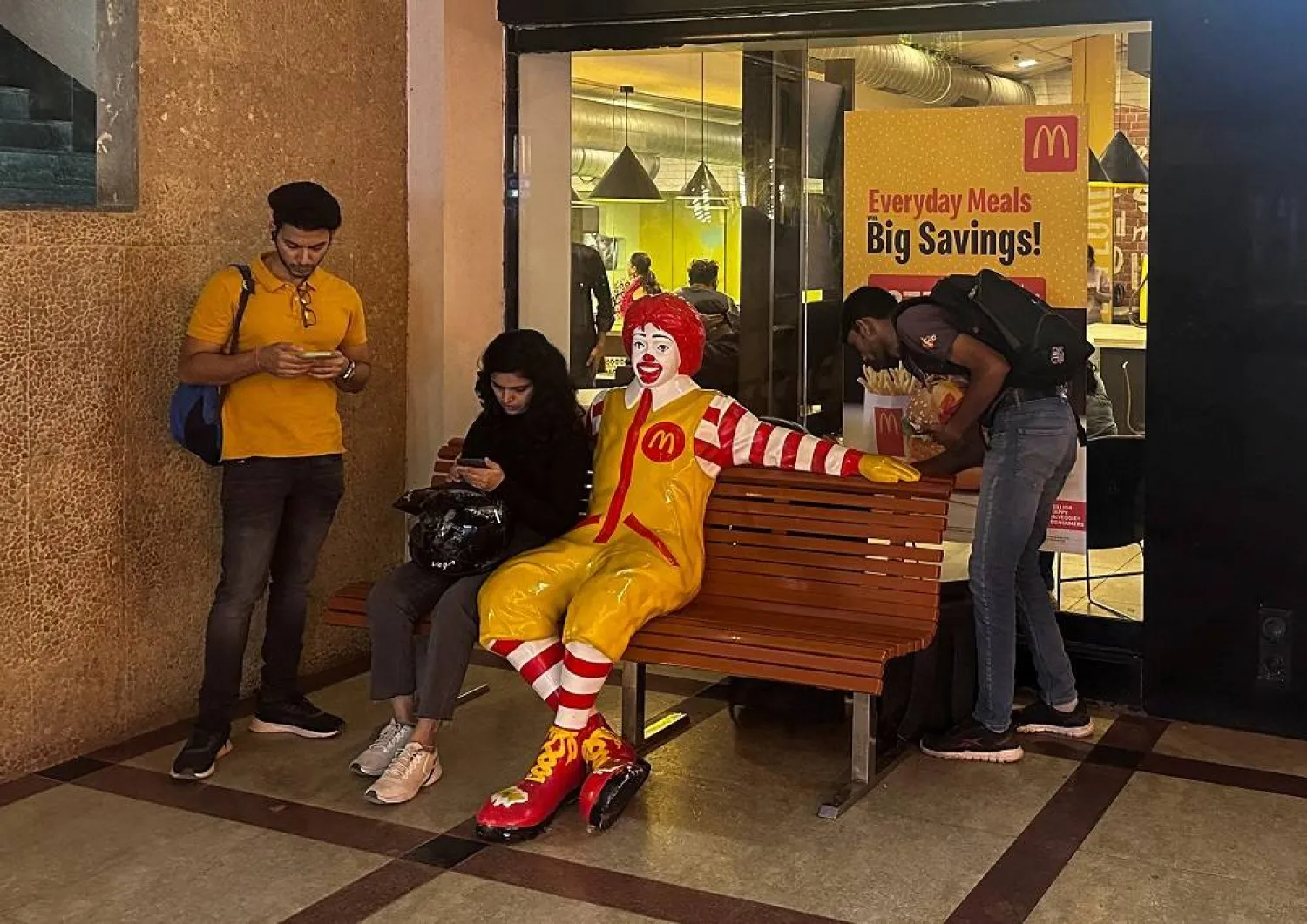 A person sits outside a McDonald's restaurant in Mumbai, India, February 26, 2024. (Reuters)