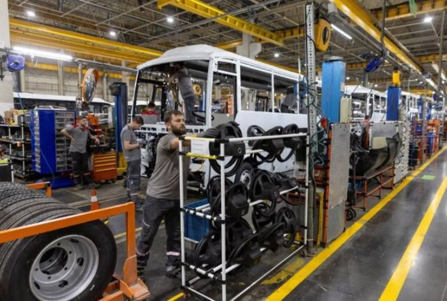 فنيون يعملون على حافلة في خط إنتاج مصنع «أوتوكار» التركي في بلدة أريفييه بمحافظة سكاريا (رويترز)