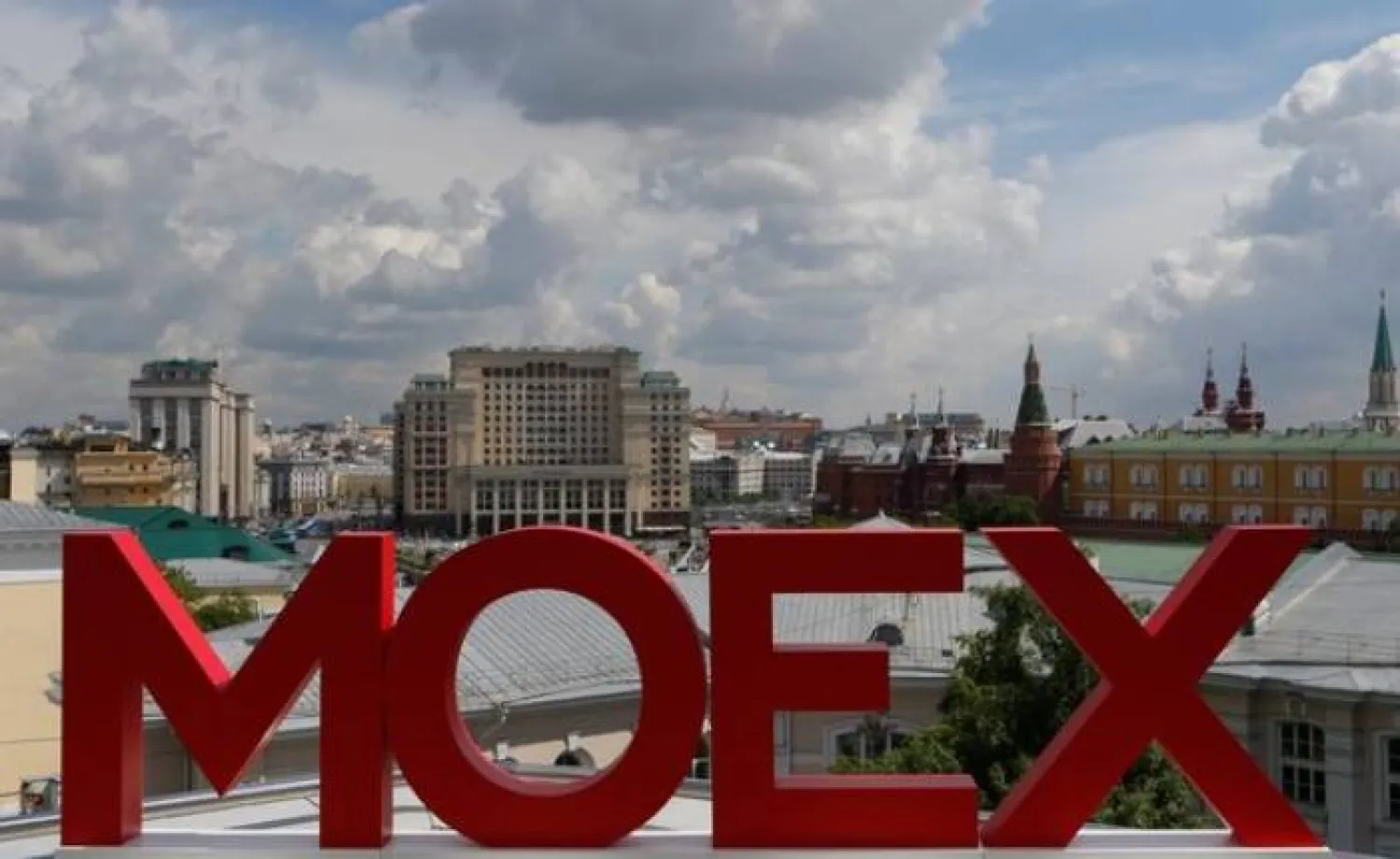 يظهر اسم بورصة موسكو مع الكرملين وفندق فور سيزونز في الخلفية (رويترز)