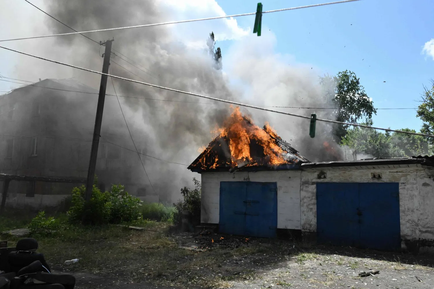 صورة تظهر مرآباً محترقاً ومبنى سكنياً متضرراً في أعقاب غارة جوية روسية بطائرة مسيّرة على بلدة بيلوزيرسكي بمنطقة دونيتسك - أوكرانيا - 10 أغسطس 2025 (أ.ف.ب)