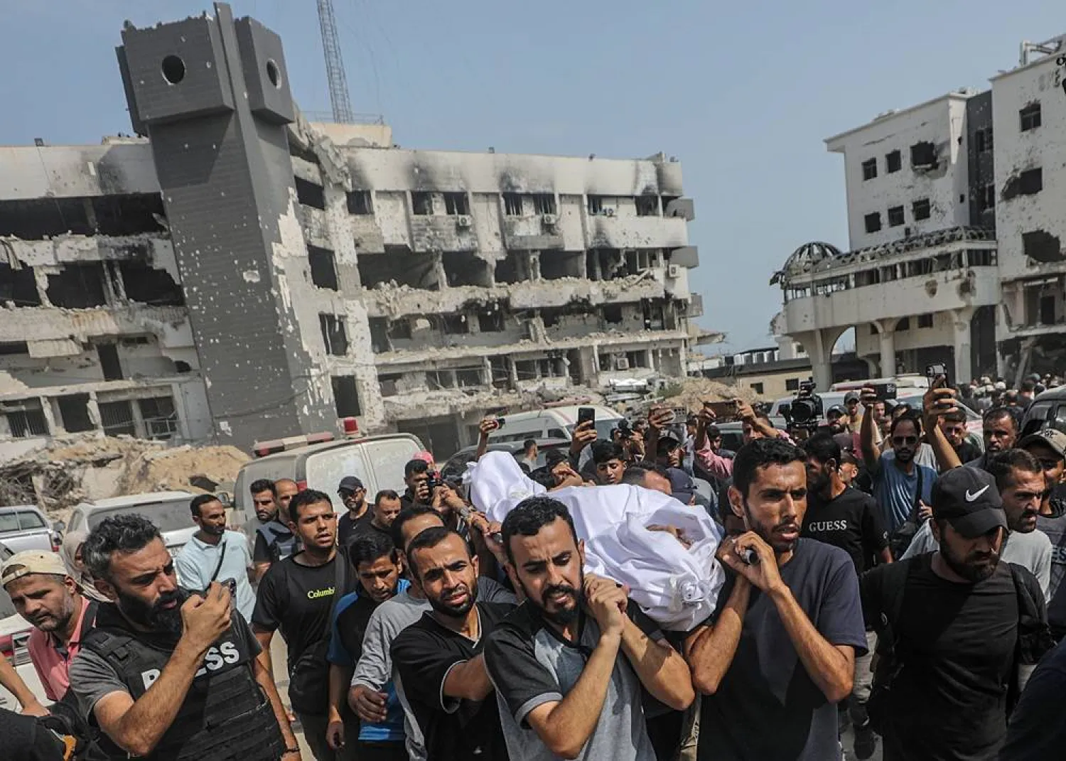 Palestinians carry the body of late Al Jazeera correspondent Mohamed Qreiqeh during his funeral, outside al-Shifa Hospital in Gaza City, 11 August 2025. (EPA)
