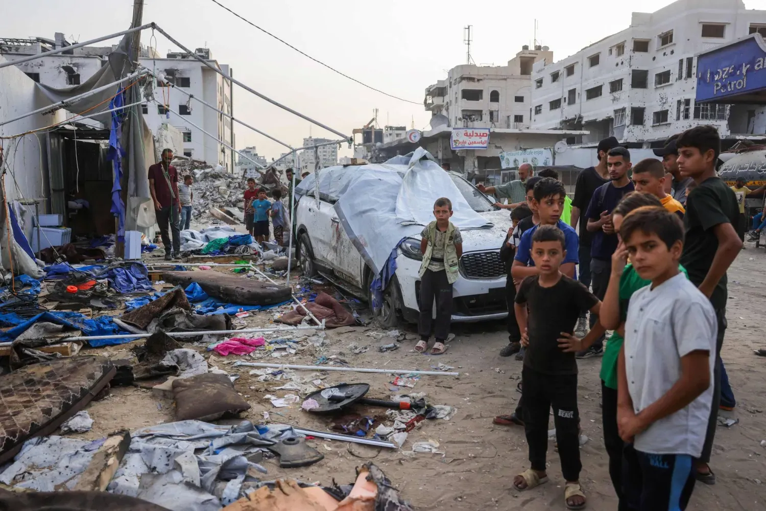 Dün İsrail'in saldırısı sonucu beş kişinin öldüğü Gazze şehrindeki Şifa Hastanesi önündeki gazeteciler çadırı önünde yas tutan Filistinliler (AFP)