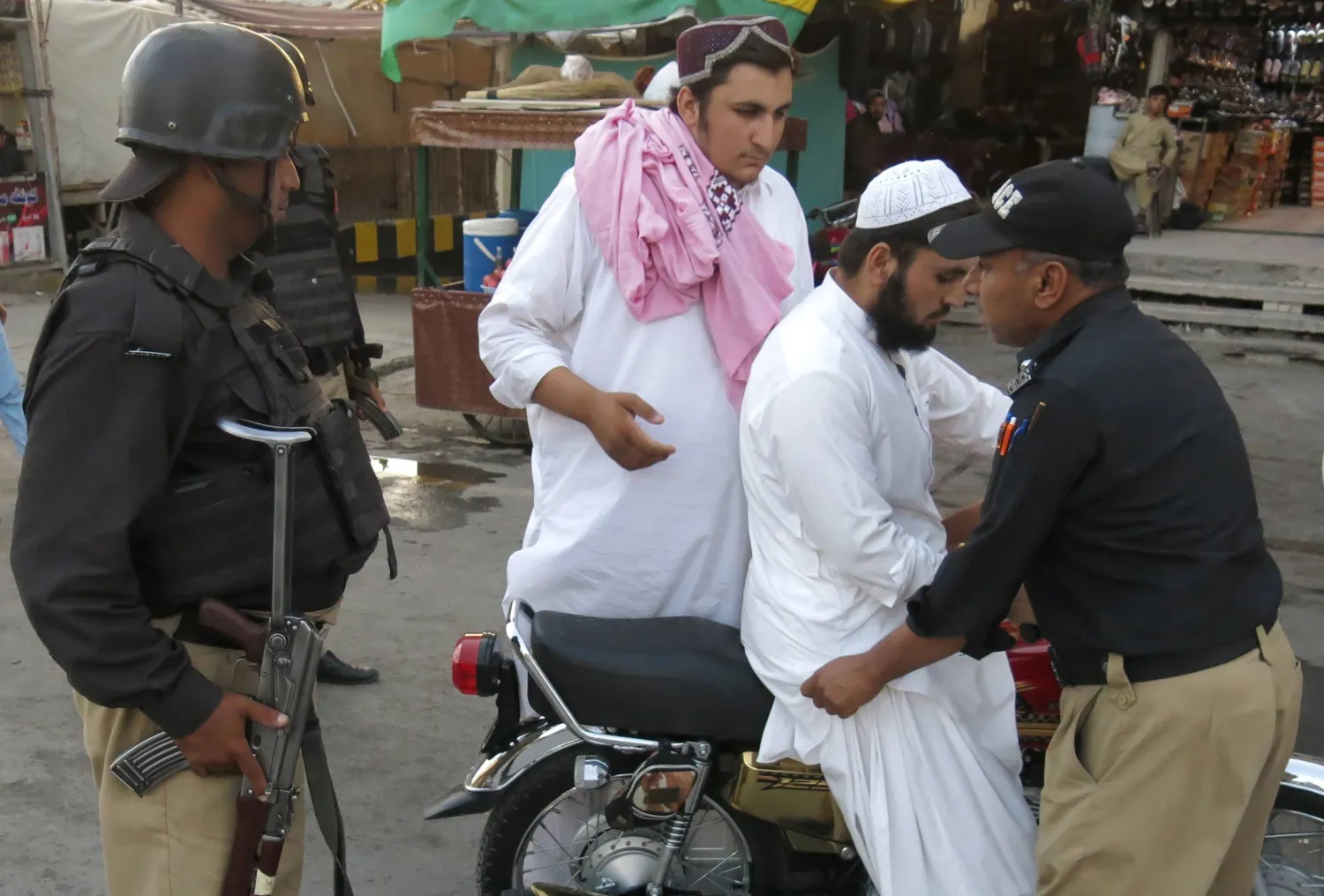 مسؤولون أمنيون باكستانيون يفتشون رجلاً عند نقطة تفتيش في كويتا عاصمة إقليم بلوشستان المضطرب 8 أغسطس (إ.ب.أ)