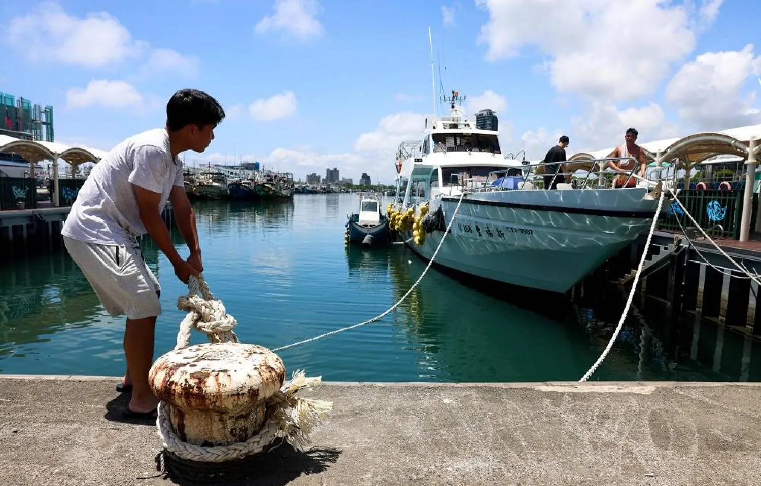 Fishermen secure their boats at Wushih Harbor in Yilan as Typhoon Podul approaches on August 12, 2025 (AFP)