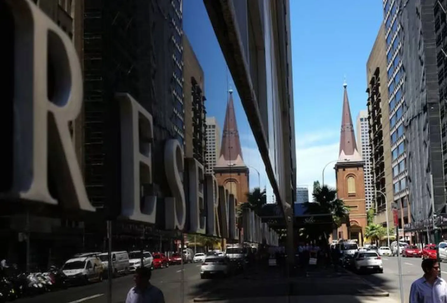 مُشاة يمرون بجانب مبنى بنك الاحتياطي الأسترالي في وسط سيدني (رويترز)