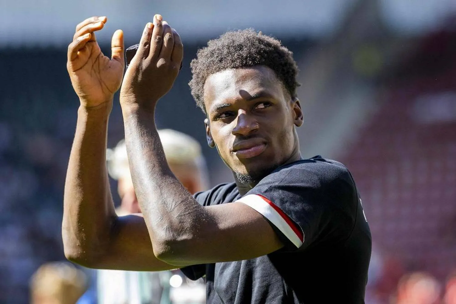 AZ Alkmaar's Dutch forward #21 Ernest Poku greets the fans after winning the Dutch Eredivisie football match between AZ Alkmar and FC Groningen at AFAS Stadion in Alkmaar on August 10, 2025. (ANP / AFP) 