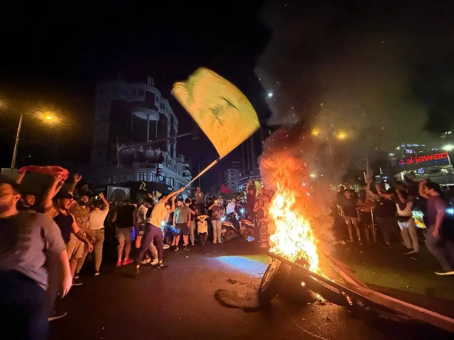 Supporters of Lebanon's Hezbollah group block the streets with burning tires as they rally in cars and motorbikes to protest the government's endorsement of a plan to disarm it, in Beirut's southern suburbs early on August 8, 2025. (AFP) 