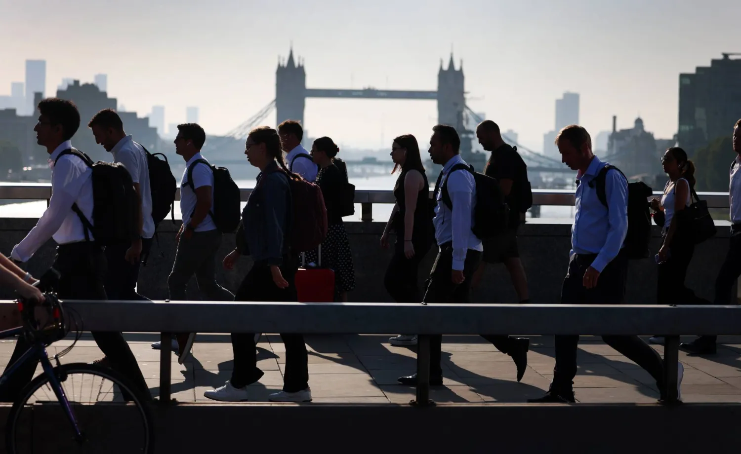 أشخاص يعبرون جسر لندن في طريقهم إلى العمل بلندن (إ.ب.أ)